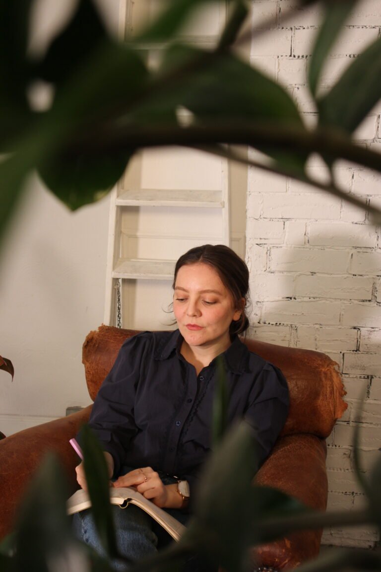 audhd coach sitting on an armchair writing down notes